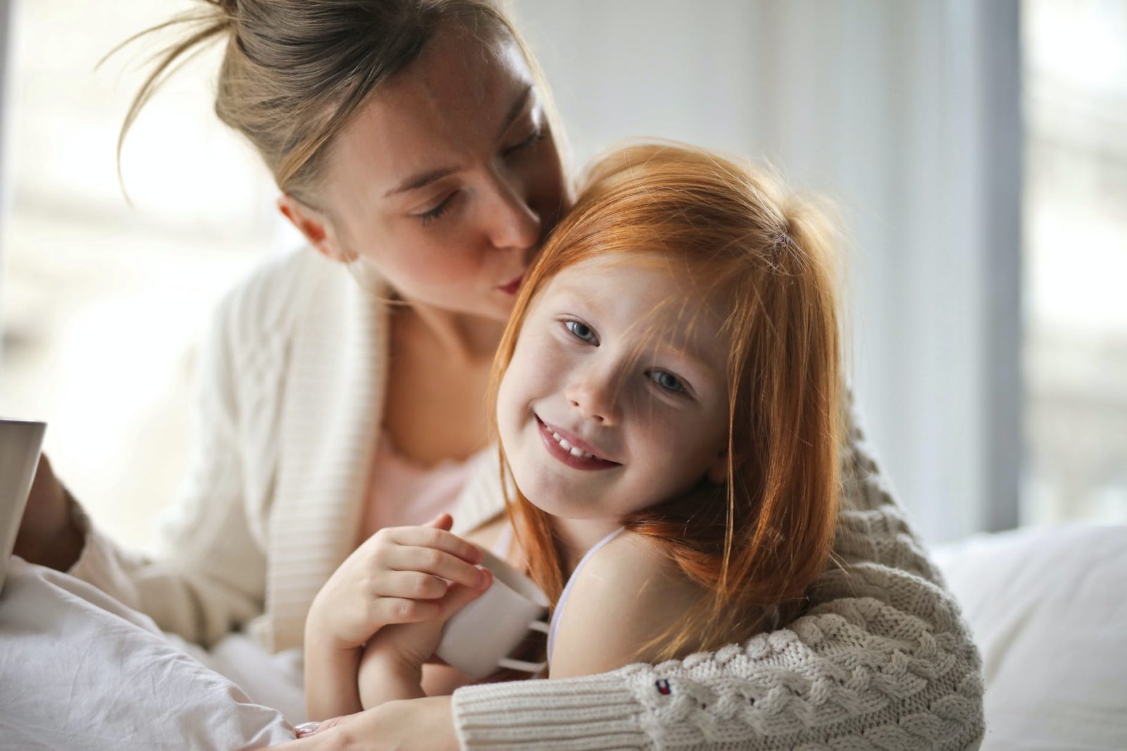 a mother kissing her child