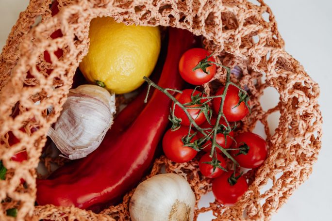 handbag with fresh assorted vegetables on table